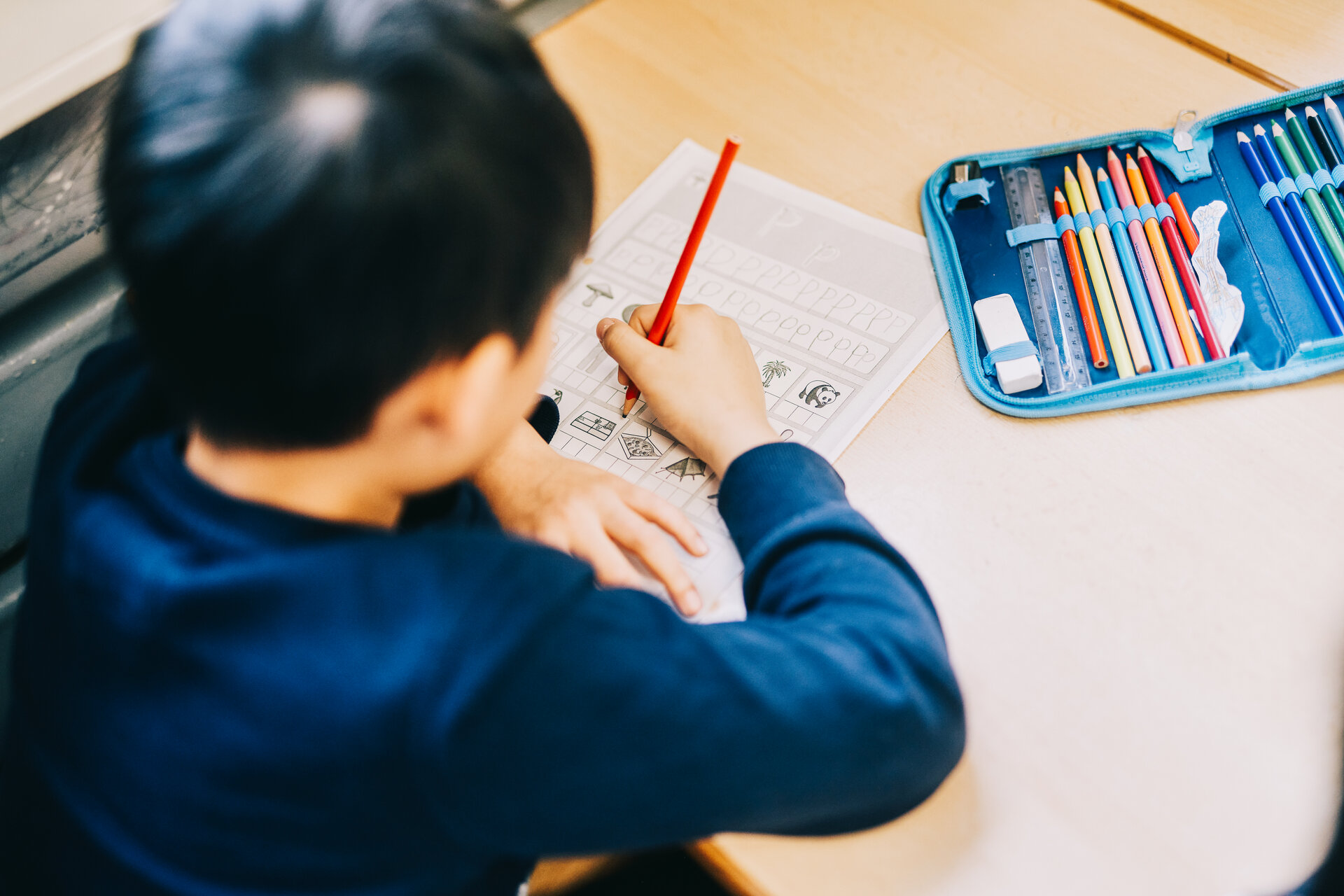 Schüler schreibt auf Arbeitsblatt